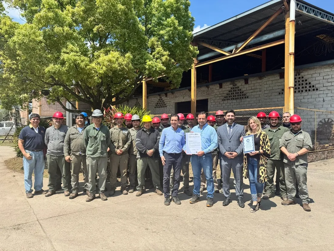 Personal con cascos reunido en una planta metalúrgica durante la entrega de un certificado
