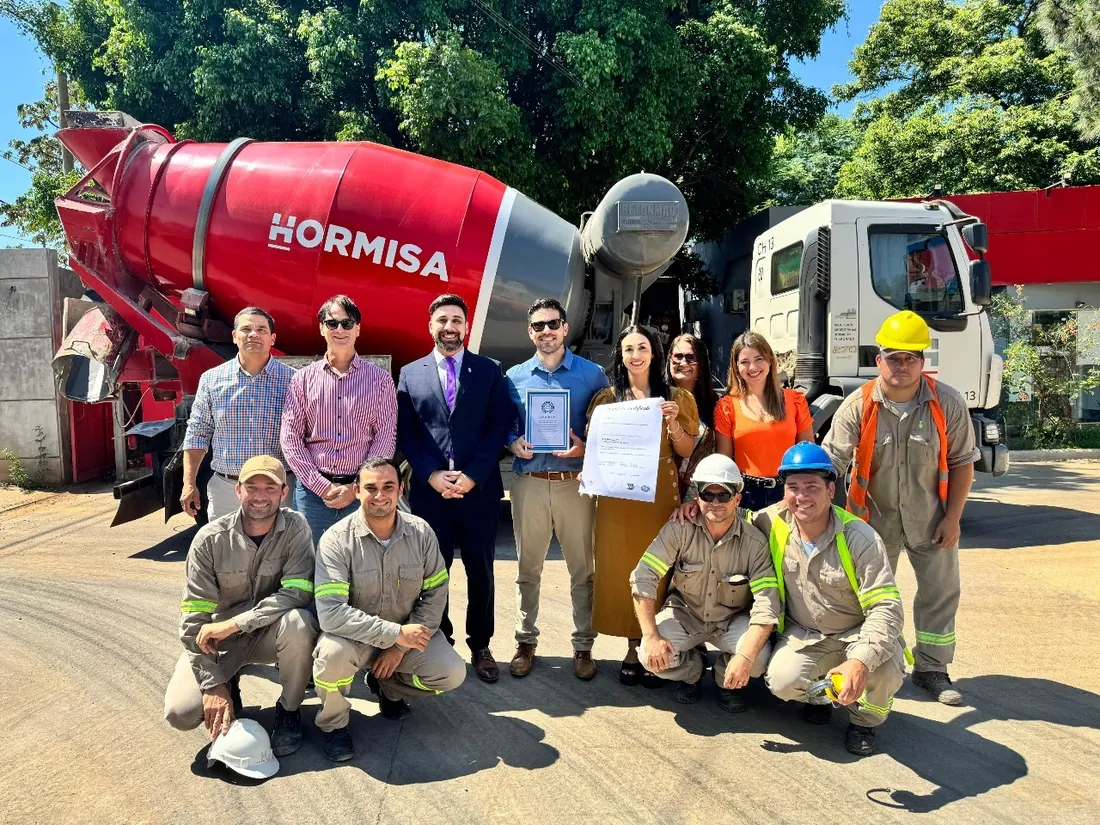 Equipo con certificados frente a un camión mezclador